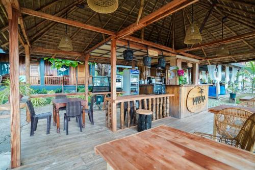 an outdoor patio with tables and chairs and a bar at Marika Resort in Badian