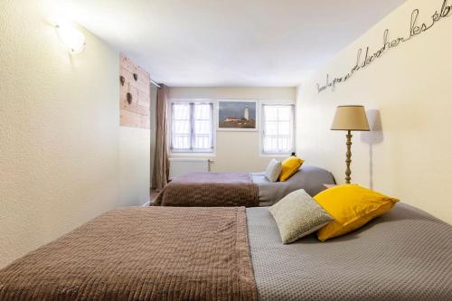 リボーヴィレにあるLe Gîte de Sandraのベッド2台が備わる小さな部屋のベッド2台