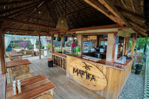 an outdoor restaurant with a bar and tables at Marika Resort in Badian