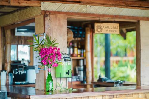 a vase of pink flowers in a bottle on a counter at Marika Resort in Badian