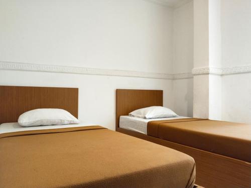 雅加達的住宿－Wisma Juanda Powered by Cocotel，两张睡床彼此相邻,位于一个房间里