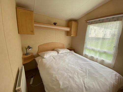 una piccola camera con letto e finestra di Caravan SK 110 a Leven-Fife