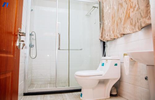 a bathroom with a shower and a toilet and a sink at Sunshine Residence in Bujumbura