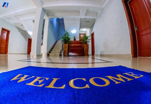 un vestíbulo con una alfombra azul de bienvenida en el suelo en Sunshine Residence, en Buyumbura