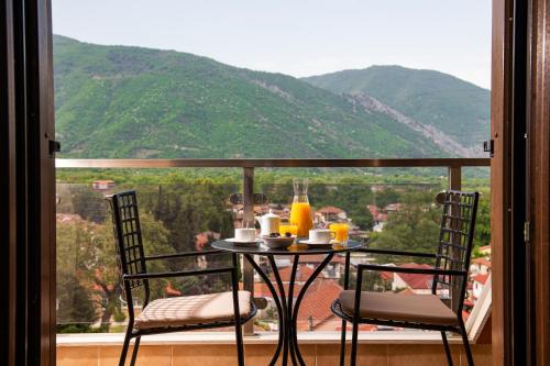 a table and two chairs on a balcony with a view at Hotel Naiades in Órma