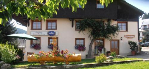 a white building with flowers in front of it at Ferienwohnung Landleben im Dorfkrug Altglashütten- Feldberg in Feldberg