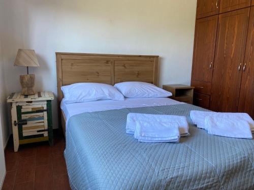 a bedroom with a bed with two towels on it at KARMA House by the River in Paramythia