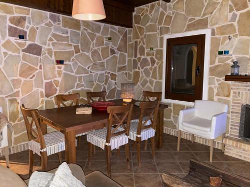 a dining room with a stone wall and a table and chairs at KARMA House by the River in Paramythia