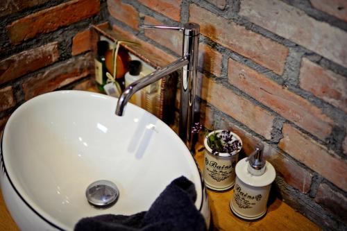 lavabo blanco en un baño junto a una pared de ladrillo en Mazurkowo domek Gaj-Grzmięca, en Zbiczno