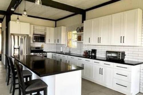 uma cozinha com armários brancos e um balcão preto em Breathtaking Mountain Views in La Union, El Salvador em La Unión