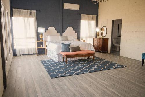 een slaapkamer met een groot wit bed en een blauw tapijt bij Breathtaking Mountain Views in La Union, El Salvador in La Unión
