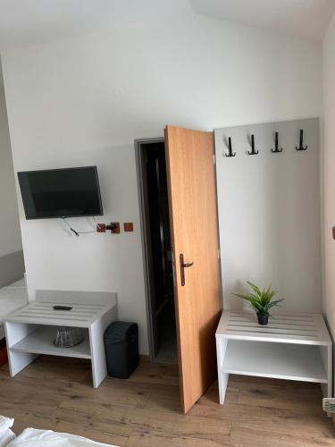 Habitación con puerta y TV en la pared en HOTEL ZELENÝ DVOR, en Senec