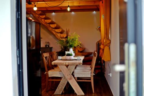 einen Holztisch und Stühle in einem Zimmer mit einer Treppe in der Unterkunft Mazurkowo domek Gaj-Grzmięca in Zbiczno