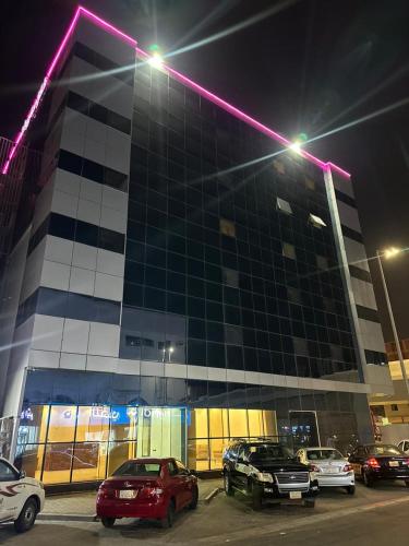 كيان حراء للشقق المخدومة- Kayan Hiraa Serviced Apartments في جدة: مبنى فيه سيارات تقف في موقف السيارات في الليل