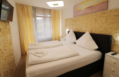 a bed with white sheets and pillows in a room at Kurhotel Schluchsee App 1003 - Ferientraum - mit Indoorpool, Sauna, Schluchsee in Schluchsee