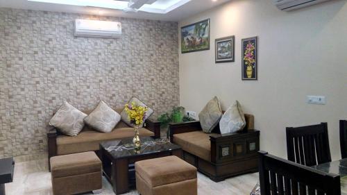 a living room with a couch and a table at Luxury Flat in Faridabad