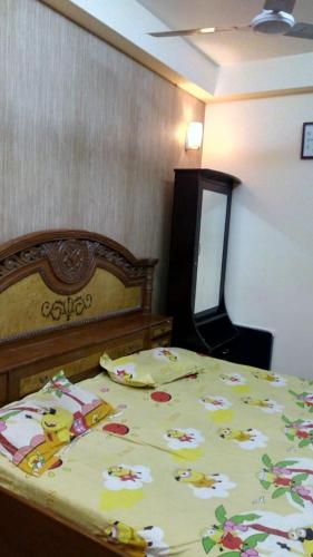 a bedroom with a bed with a comforter on it at Luxury Flat in Faridabad