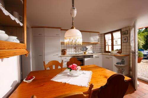 a kitchen with a wooden table with flowers on it at Ferienhaus im Gässle, Kirchzarten, Dreisamtal in Kirchzarten