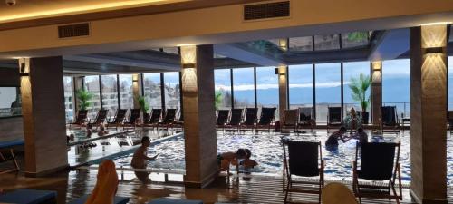 a pool in a hotel lobby with people in the water at Apartman Marković - Milmari welnes & spa resort Kopaonik in Kopaonik