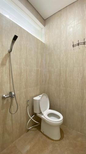 a bathroom with a toilet with a shower nozzle at Mallory Villa in Batu
