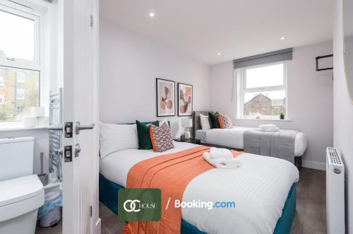 two beds in a small room with windows at Elegant 2 Bed Harbour Front Flat By OC House Short Lets & Serviced Accommodation Gillingham, Ramsgate, Folkestone With Balcony in Kent