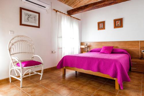 a bedroom with a purple bed and a chair at Rodenas Valero Alborea in Alborea