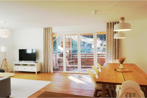 a living room with a table and chairs and a television at Haus Wiesenquelle - Fewo 10 "Uff'm Berg", Feldberg in Rinken