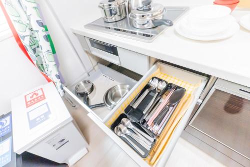 a kitchen with an open drawer with utensils at Tokyo Private House 大塚の宿 in Tokyo
