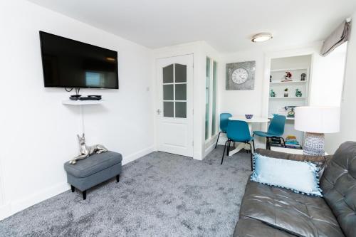 Seaview Cottage Central Dundee في دندي: غرفة معيشة مع أريكة وطاولة