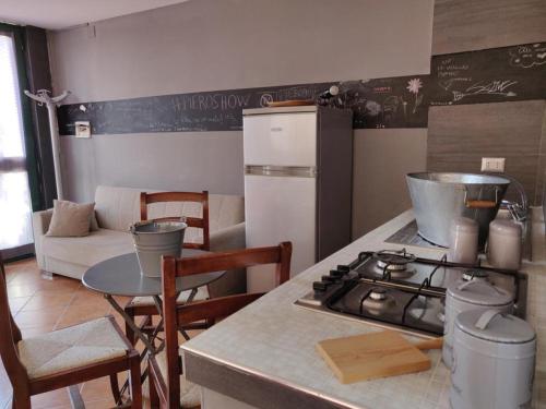 Il comprend une cuisine équipée d'une cuisinière et d'une table avec des chaises. dans l'établissement Villa Venturini, à Trecase