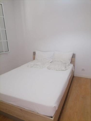 een wit bed met witte lakens en kussens bij esthela home 2 in Funchal