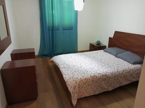 een slaapkamer met een bed en een blauw gordijn bij esthela home 2 in Funchal