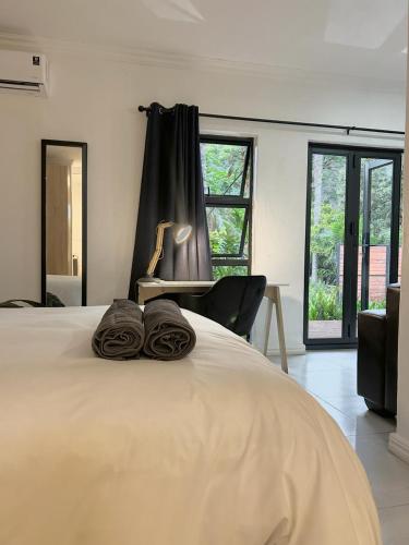 - un lit avec des serviettes assises au-dessus dans l'établissement Apartment close to Menlyn Maine, à Pretoria