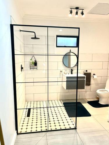 La salle de bains est pourvue d'une douche en verre, d'un lavabo et de toilettes. dans l'établissement Apartment close to Menlyn Maine, à Pretoria