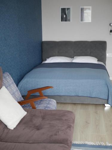 a bedroom with a bed and a couch and a chair at Prestige Apartments, центр, парковка, електрозаправка in Rivne