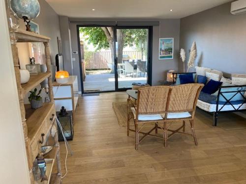 un salon avec une table, des chaises et un canapé dans l'établissement Villa à 2 min à pied de la plage, à Arcachon