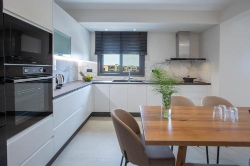 a kitchen with a wooden table and a dining room at Pomaria Boutique Residences in Lefkada Town