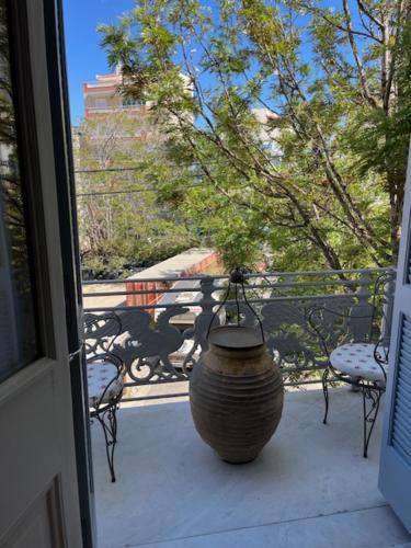 a large vase sitting on a porch next to a window at 1906 Citygarden in Chios