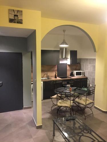 une cuisine avec une table avec des chaises et un micro-ondes dans l'établissement LE SOLEIL DE MARSEILLE, à Marseille