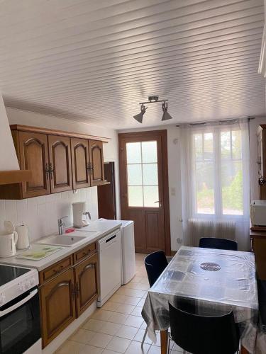 une cuisine avec des armoires en bois et une table avec des chaises dans l'établissement Domaine du Mont des Chênes, à Monthou-sur-Cher