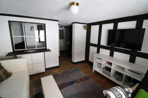 a living room with a flat screen tv and white cabinets at Ferienwohnung Michel 02 im Haus Schwarzwaldmarille- Todtnauberg, Feldberg - b45630 in Todtnau