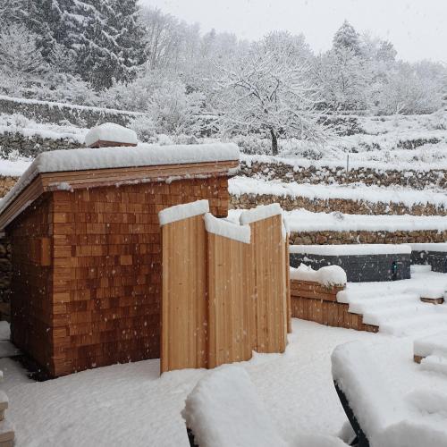 a fence covered in snow in a yard at ARPA DI PIETRA - Luxury B&B SPA BIO - Adults Only in Mori