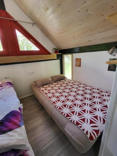 ein Schlafzimmer mit einem Bett in einem winzigen Haus in der Unterkunft Babičina hišica in Mišji Dol