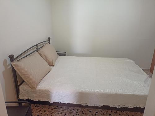 a bed in a room with a white wall at Machouse in Mytilene