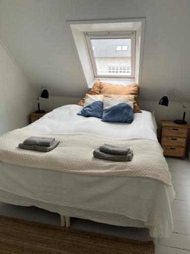 a bedroom with a large bed with two pillows on it at Holbæk. Byhus med fjordudsigt, og 5 min. til bymidten in Holbæk