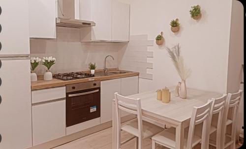 a kitchen with a table with chairs and a stove at Dentro le Mura-Suite House in Sassari