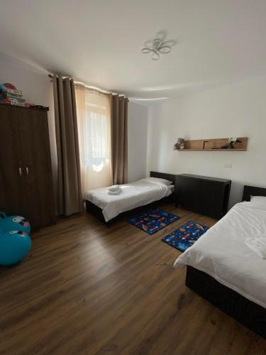 a room with two beds and a wooden floor at Casa Bellevue in Bacău