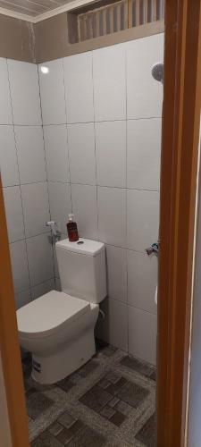 a bathroom with a white toilet in a room at Aquila Family Homestay in Lampung