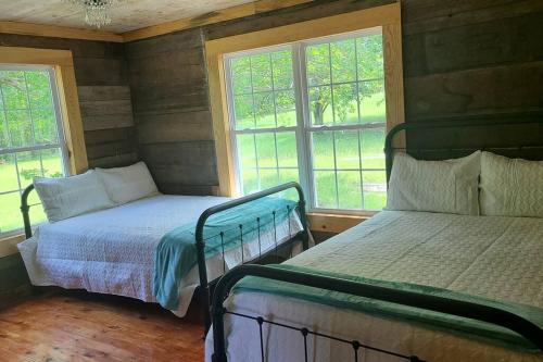 a bedroom with two beds and two windows at Back in time 1940s Lakeview House in South Toledo Bend