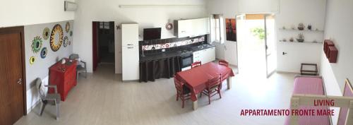 a living room with a table and a kitchen at Bilocali Approdo "Fronte Mare" e "Lato Strada" in Porto Cesareo